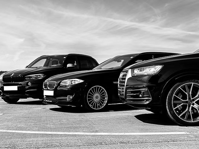Drie zwarte wagens naast elkaar geparkeerd – onderhoud van bedrijfswagens